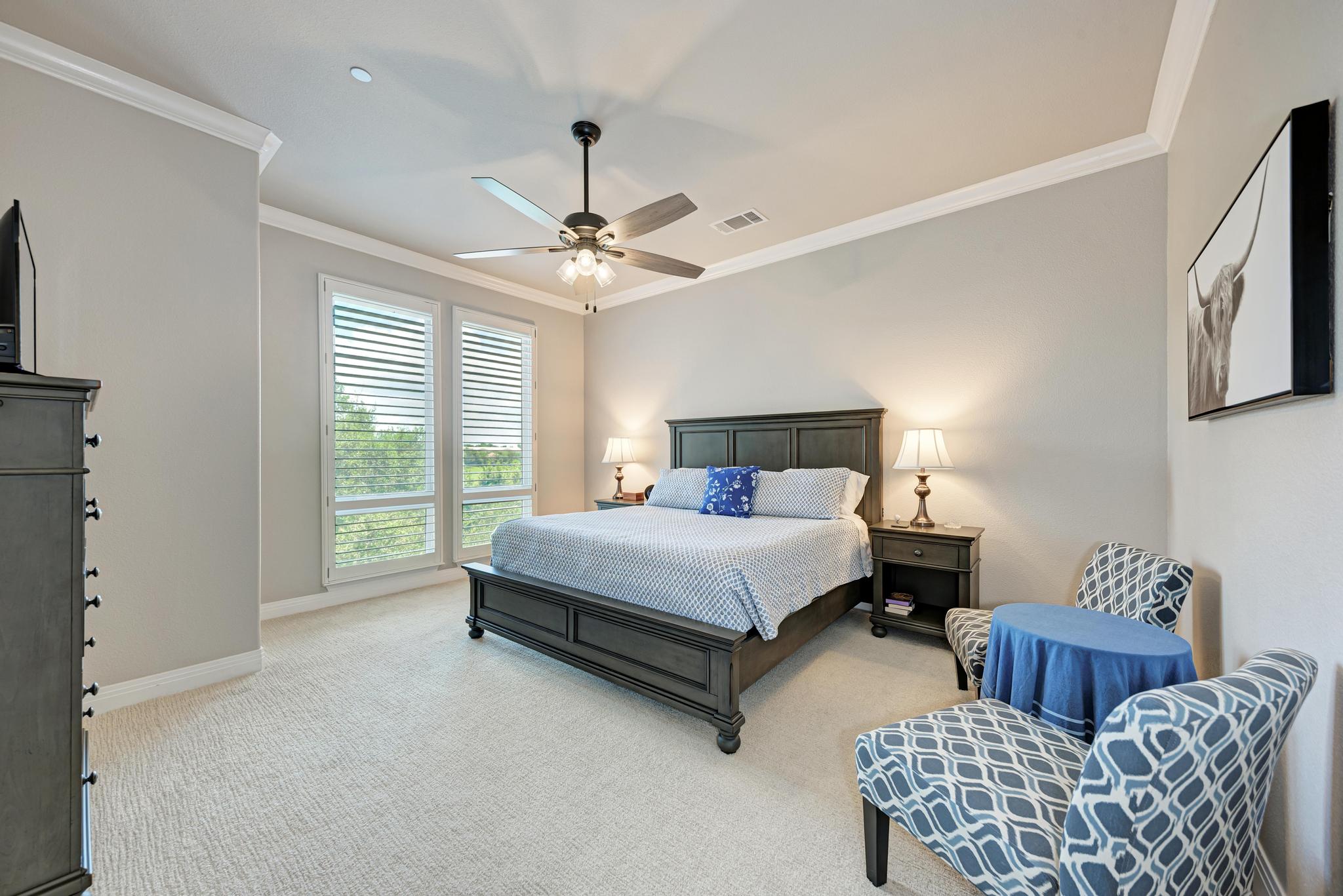 2601 North Quinlan Park Road, Unit 506 Austin, TX 78732 - Photo 23 of 39 Plush carpeting and crown molding highlight this cozy, well-lit bedroom space.