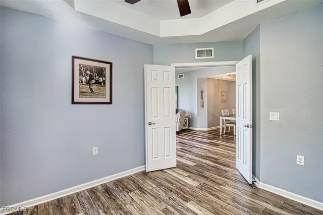a view of a hallway with wooden floor and closet