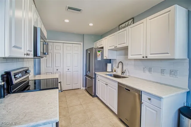 a kitchen with granite countertop a sink stove and cabinets