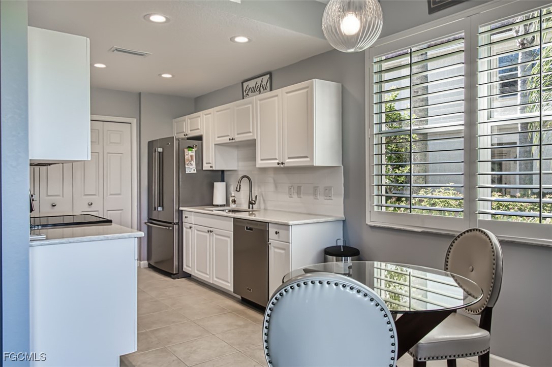 3111 Meandering Way, Unit 101 Fort Myers, FL 33905 - Photo 18 of 50 a kitchen with kitchen island granite countertop a sink cabinets a window and stainless steel appliances