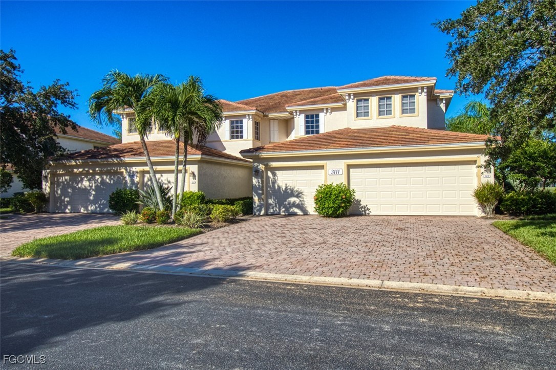 3111 Meandering Way, Unit 101 Fort Myers, FL 33905 - Photo 2 of 50 a front view of a house with a yard and a garage