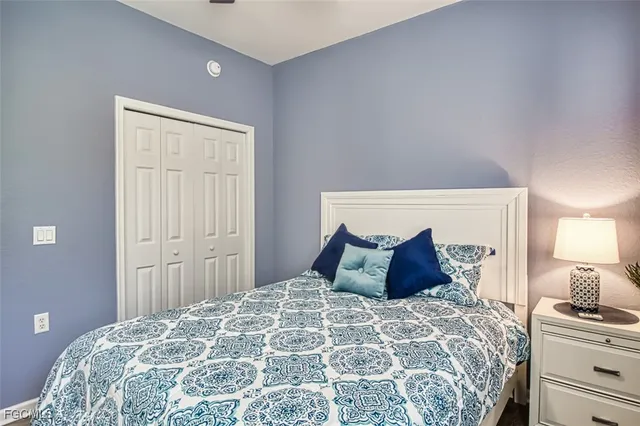 a bedroom with a large bed and a lamp