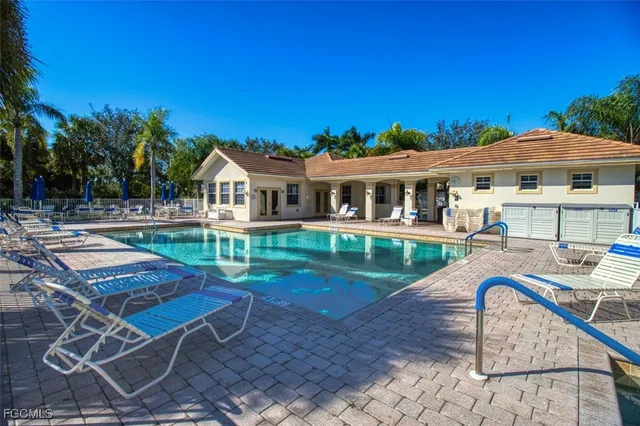 a view of a patio with couches table and chairs under an umbrella