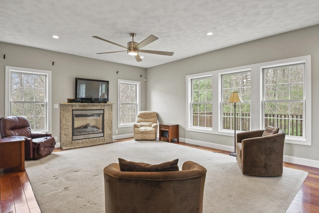 25 Wilkes Road Rowley, MA 01969 - Photo 8 of 40 a living room with furniture a fireplace and a flat screen tv