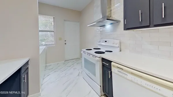 a kitchen with granite countertop a sink cabinets and stainless steel appliances