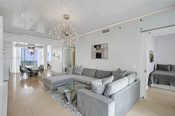 a living room with furniture and a chandelier