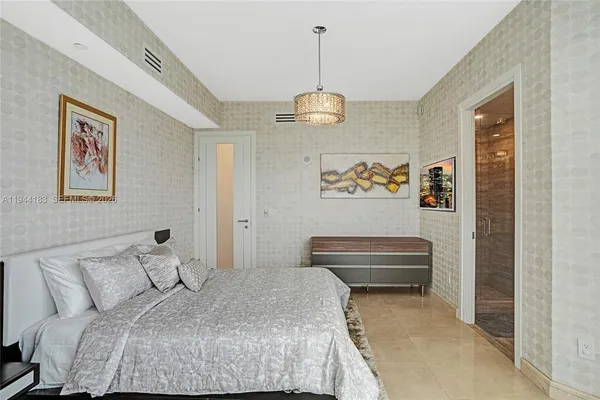 a bedroom with two beds and a chandelier