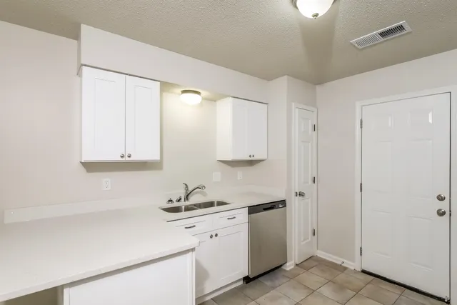 a view of an empty room with wooden floor and window