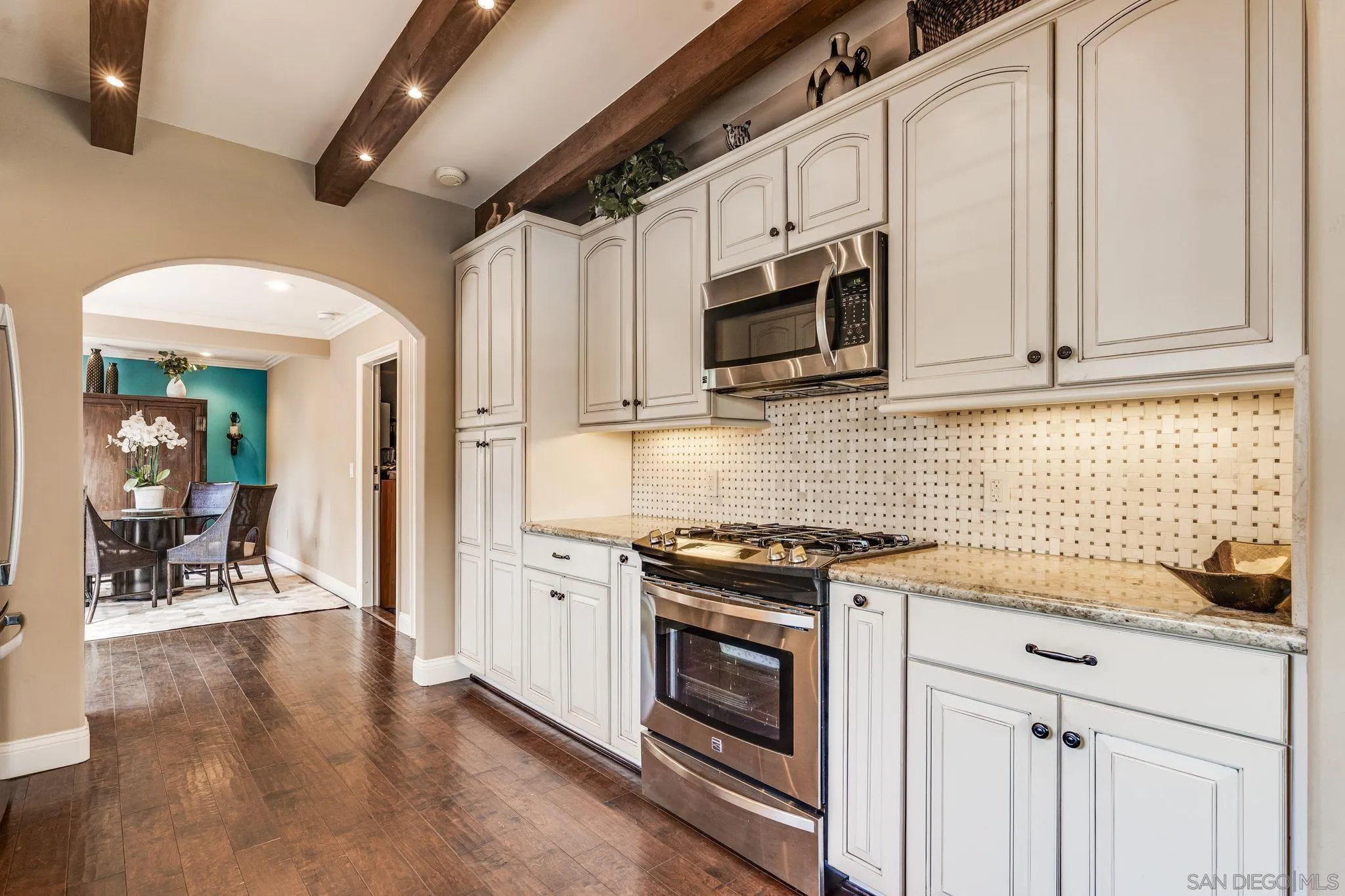 818 Genter Street La Jolla, CA 92037 - Photo 5 of 26 a kitchen with stainless steel appliances granite countertop a stove a microwave and a refrigerator
