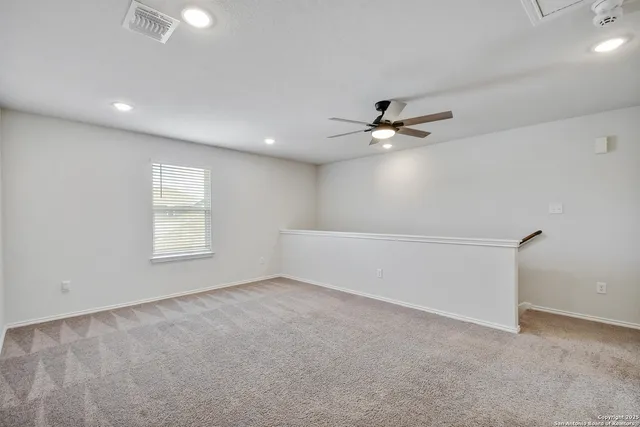 an empty room with fan and windows