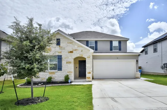 a front view of a house with a garden and yard