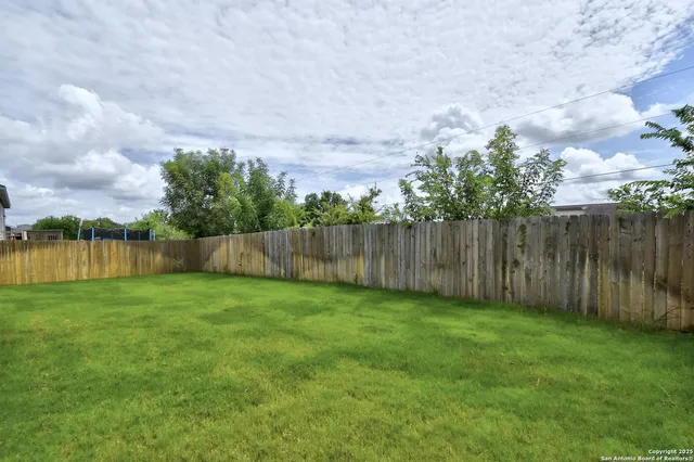 a backyard of a house with wooden deck and furniture