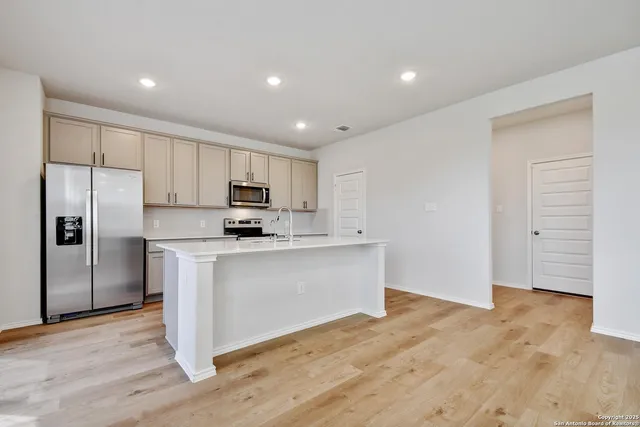 a kitchen with granite countertop a refrigerator and a stove top oven