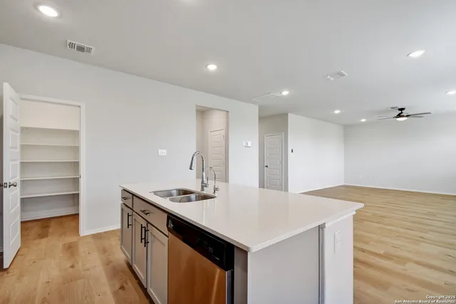 a kitchen with a sink vanity and a refrigerator