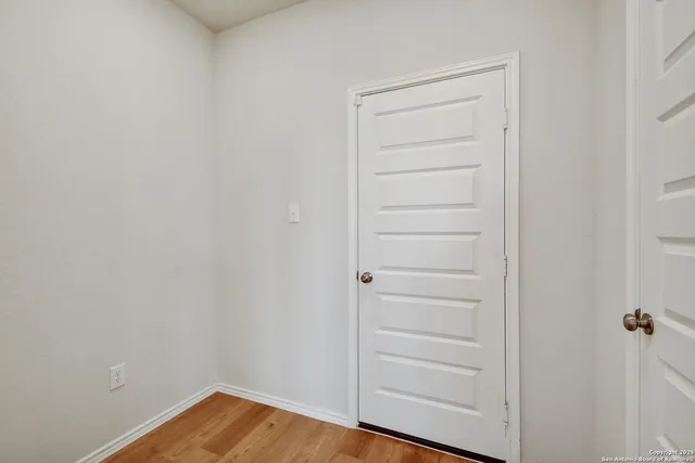 a view of a closet area with hardwood floor