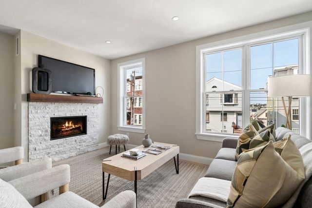 a living room with furniture a fireplace and a flat screen tv