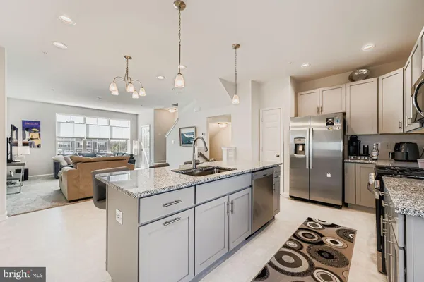 a kitchen with stainless steel appliances granite countertop a sink a stove and refrigerator