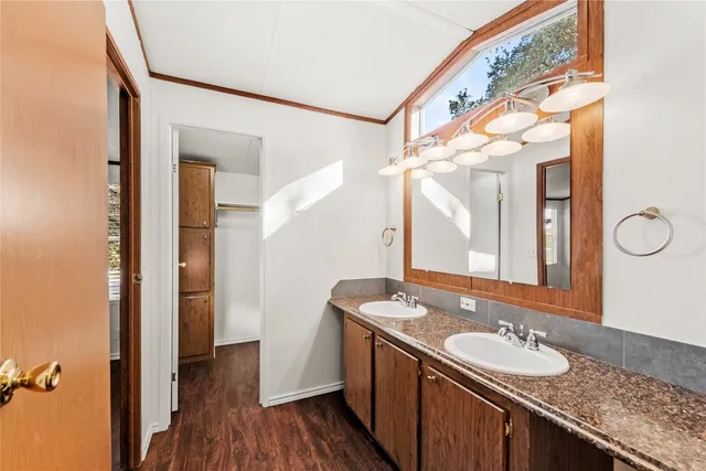 a bathroom with a granite countertop sink a mirror and a shower