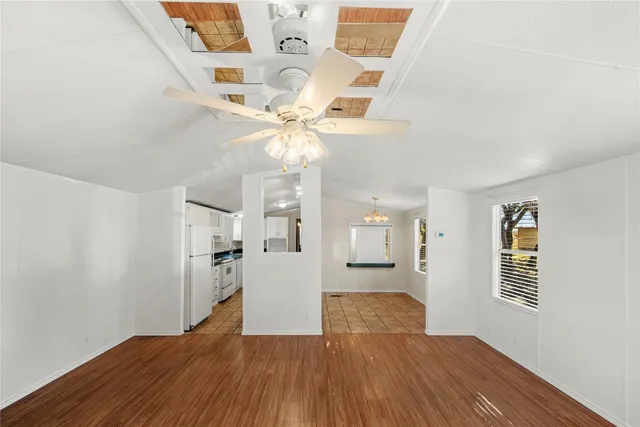 a view of a big room with wooden floor and windows