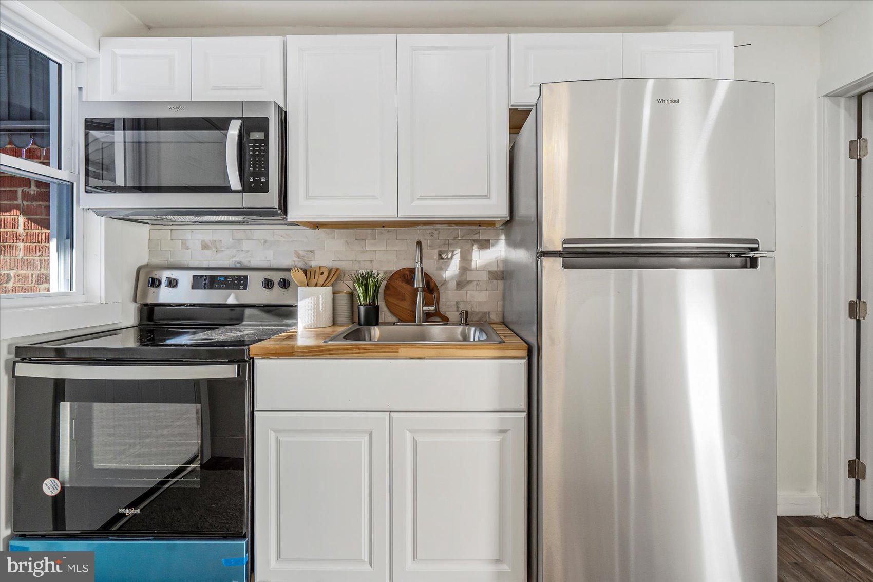 3925 Chesterfield Avenue Baltimore, MD 21213 - Photo 13 of 35 a kitchen with stainless steel appliances granite countertop a refrigerator stove and microwave