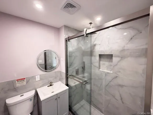 a bathroom with a toilet sink vanity and mirror