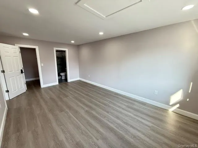 a view of empty room with wooden floor