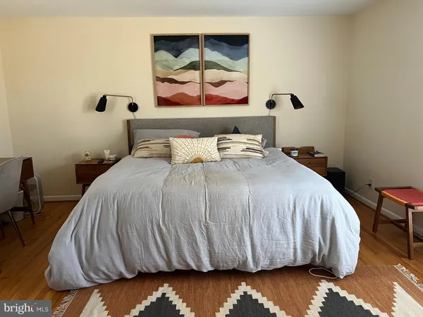 a bedroom with a bed and painting on the wall