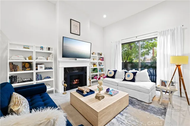 a living room with furniture a rug a fireplace and a large window