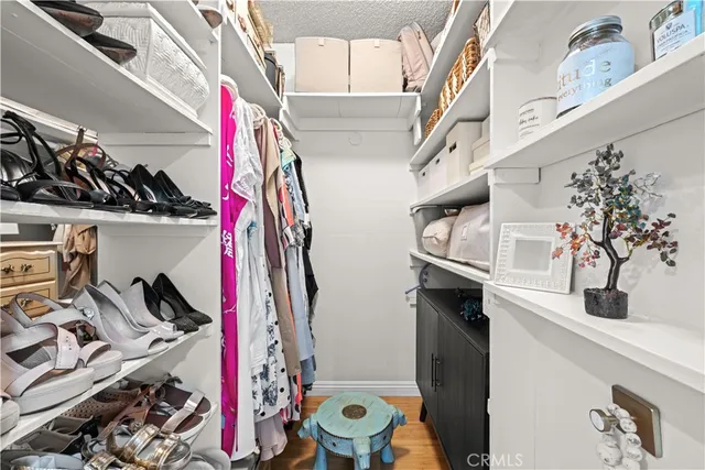 a view of walk in closet with clothes and shoes
