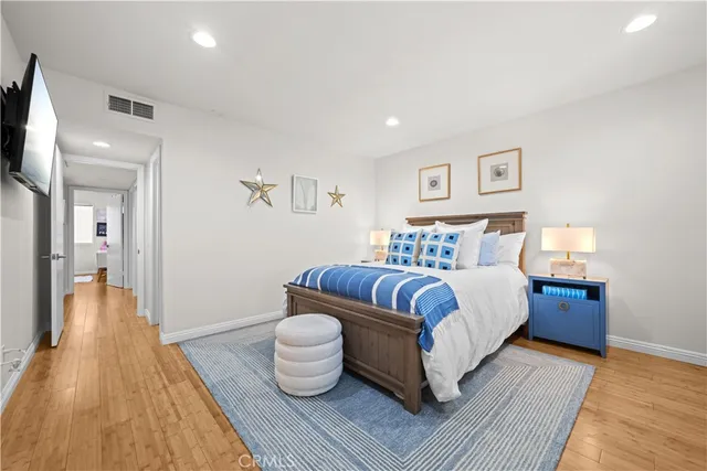 a spacious bedroom with a bed and wooden floor