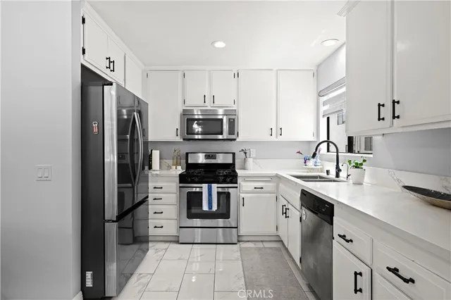a kitchen with stainless steel appliances a refrigerator sink and microwave