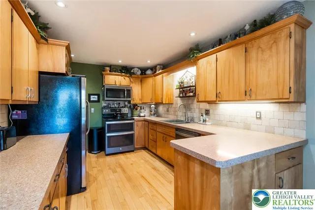 a kitchen with stainless steel appliances granite countertop a sink a stove and cabinets