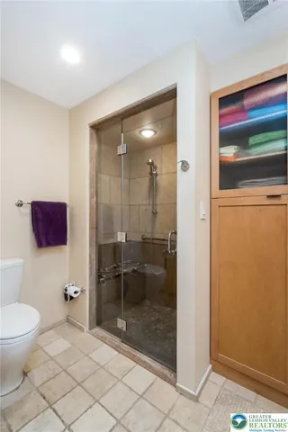 a bedroom with a bed a dresser and a chandelier