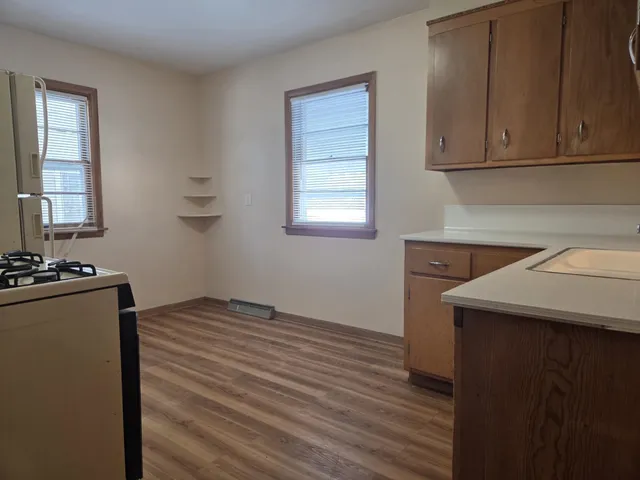a kitchen with a sink cabinets and wooden floor