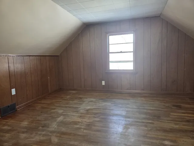 an empty room with wooden floor and windows in it
