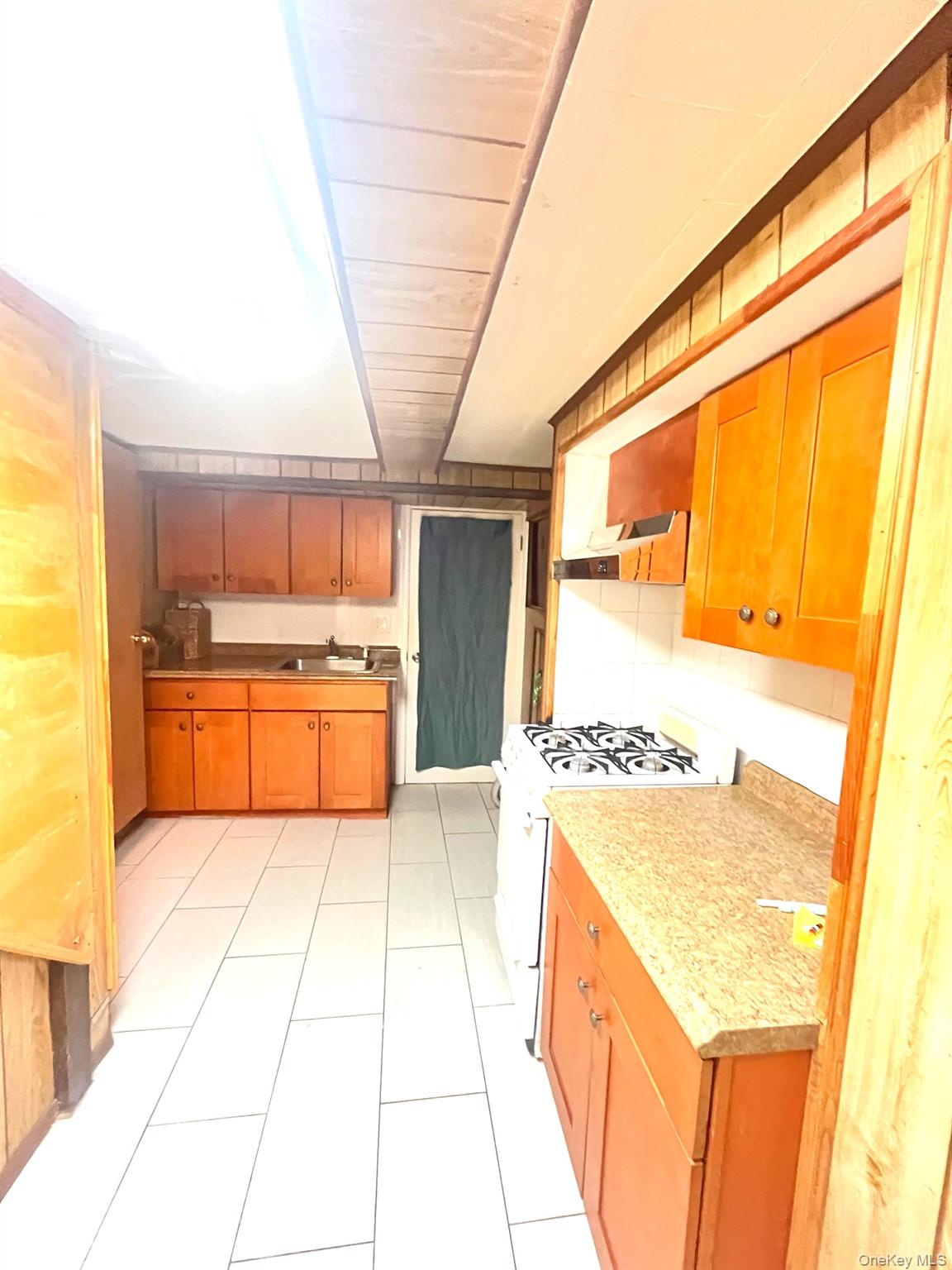 1945 Paulding Avenue Bronx, NY 10462 - Photo 7 of 12 a large kitchen with a stove a sink and a refrigerator