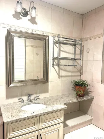 a bathroom with a granite countertop sink and a window