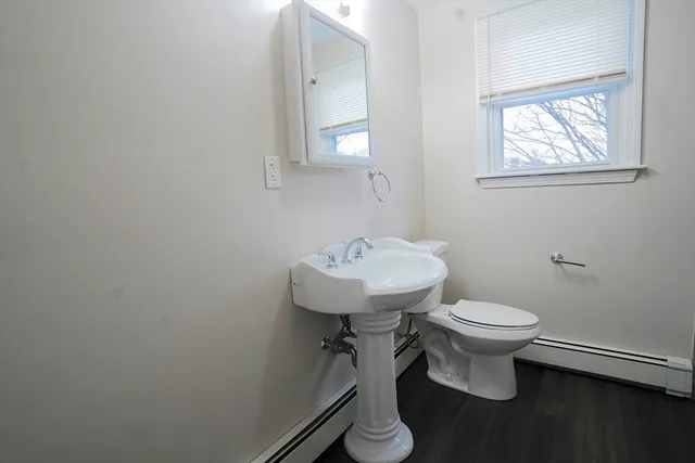 a bathroom with a toilet a sink and mirror