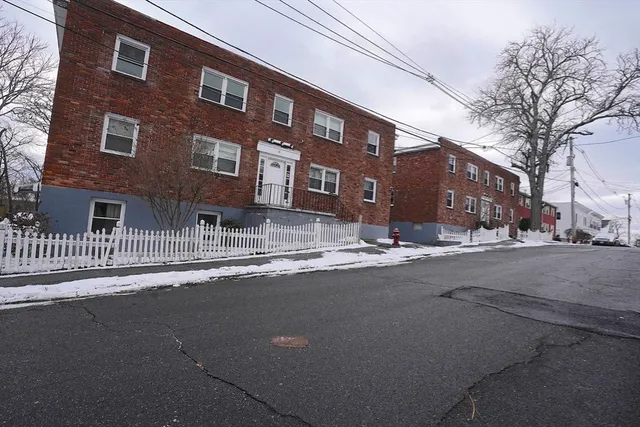 a front view of building with road and trees