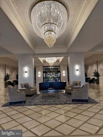 a lobby with furniture and a chandelier