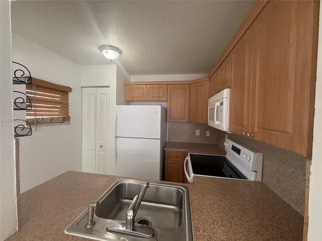 a kitchen with a refrigerator and a sink
