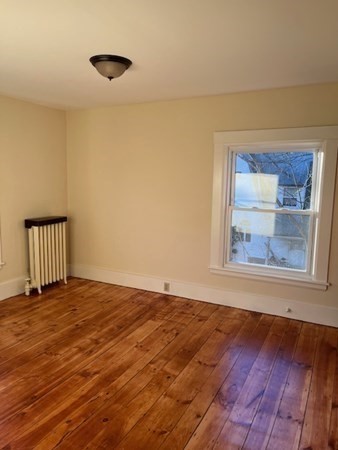36 Cambridge Street Ayer, MA 01432 - Photo 17 of 28 a view of an empty room with a window and wooden floor