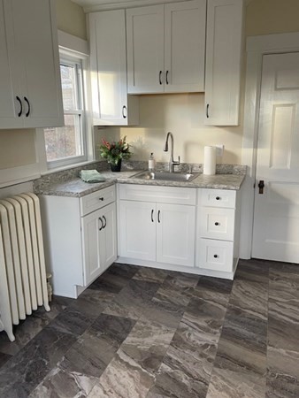 36 Cambridge Street Ayer, MA 01432 - Photo 6 of 28 a kitchen with granite countertop white cabinets white appliances and sink