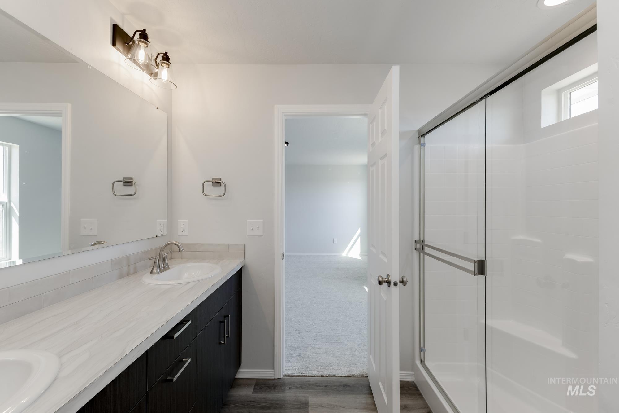 13681 Inman Court Caldwell, ID 83607 - Photo 30 of 31 Full bath with a stall shower, double vanity, dark colored carpet, and dark wood finished floors