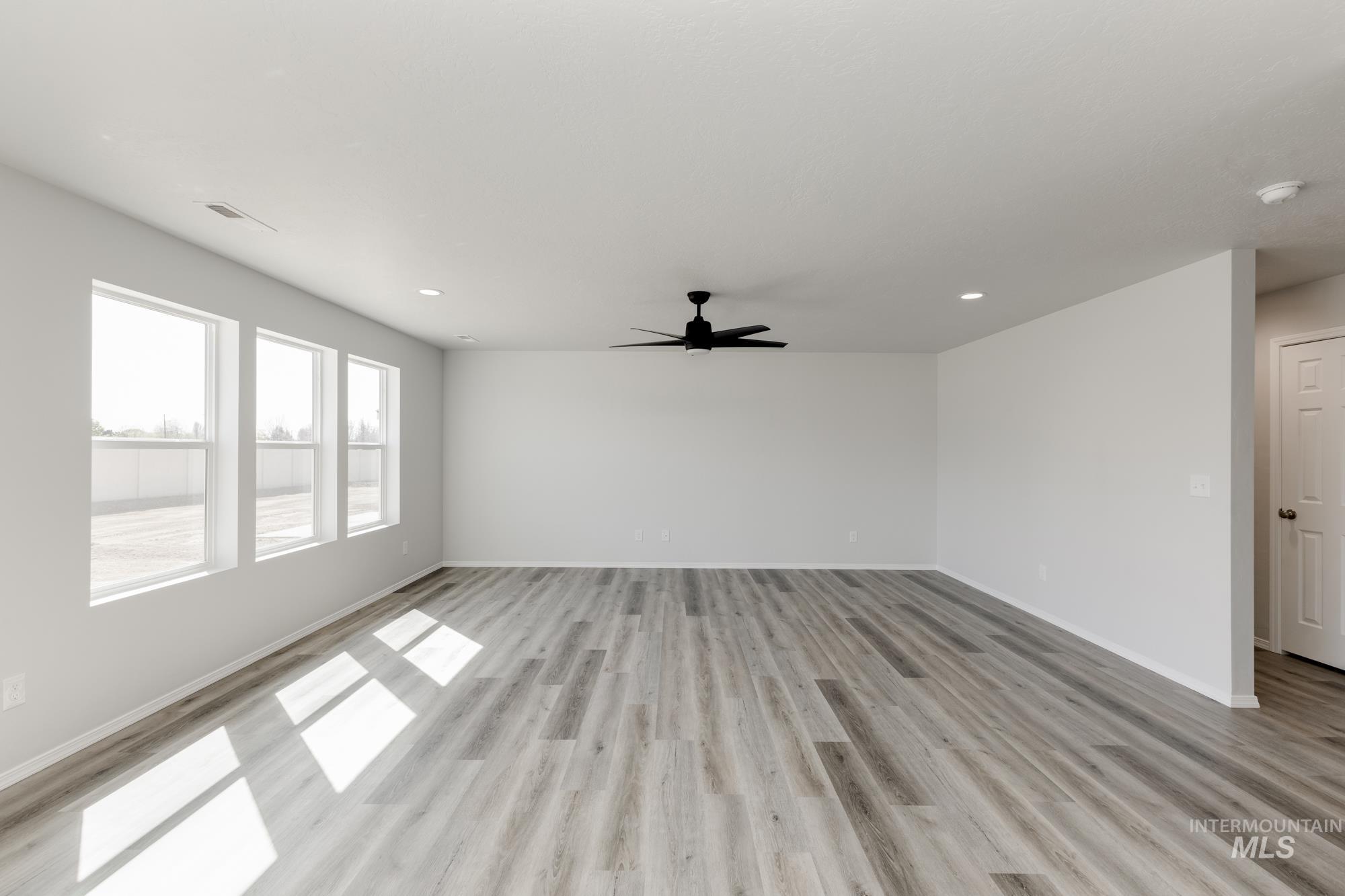 13681 Inman Court Caldwell, ID 83607 - Photo 10 of 31 Unfurnished living room featuring light wood-style floors, ceiling fan, and recessed lighting