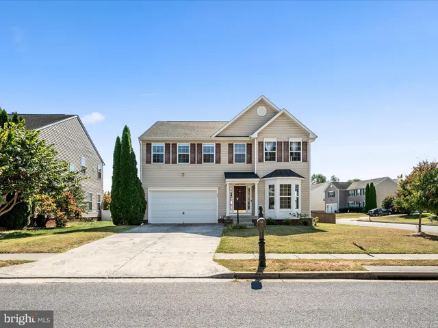 a kitchen with granite countertop a stove a sink and a refrigerator