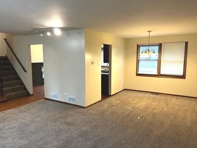 an empty room with windows and fireplace
