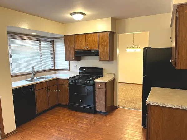 a kitchen with stainless steel appliances granite countertop a stove a sink and a refrigerator