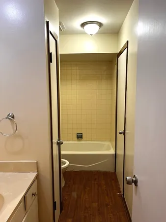 a bathroom with a tub shower vanity and a sink