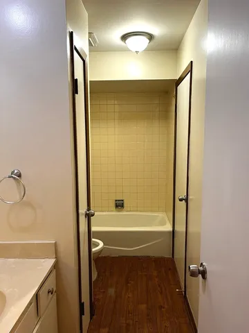 a bathroom with a tub shower vanity and a sink